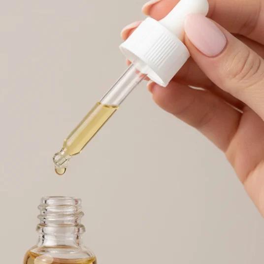 Cibdol CBD oil dropper releasing a drop above the open bottle